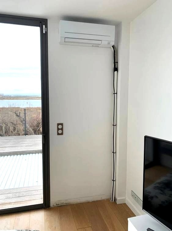 Pose d’une climatisation murale compacte avec liaisons dissimulées par coffrage en bois à Baillargues (34)